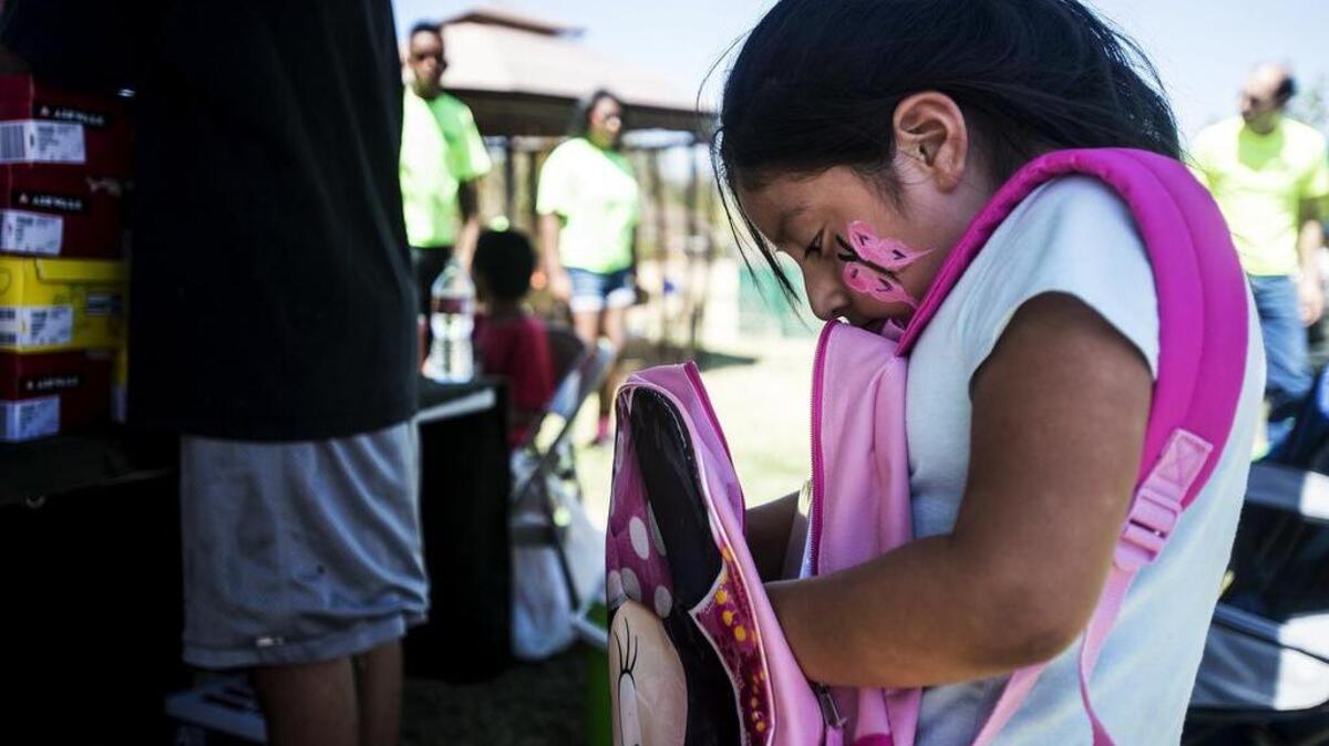 
Kristen Ramirez, 7, of Merced looks inside her new backpack during a community event that provided backpacks and shoes to children at McNamara Park on Saturday. The backpacks were provided by Distinguished Outreach Services, and shoes were provided by the TLC Collaborative.
