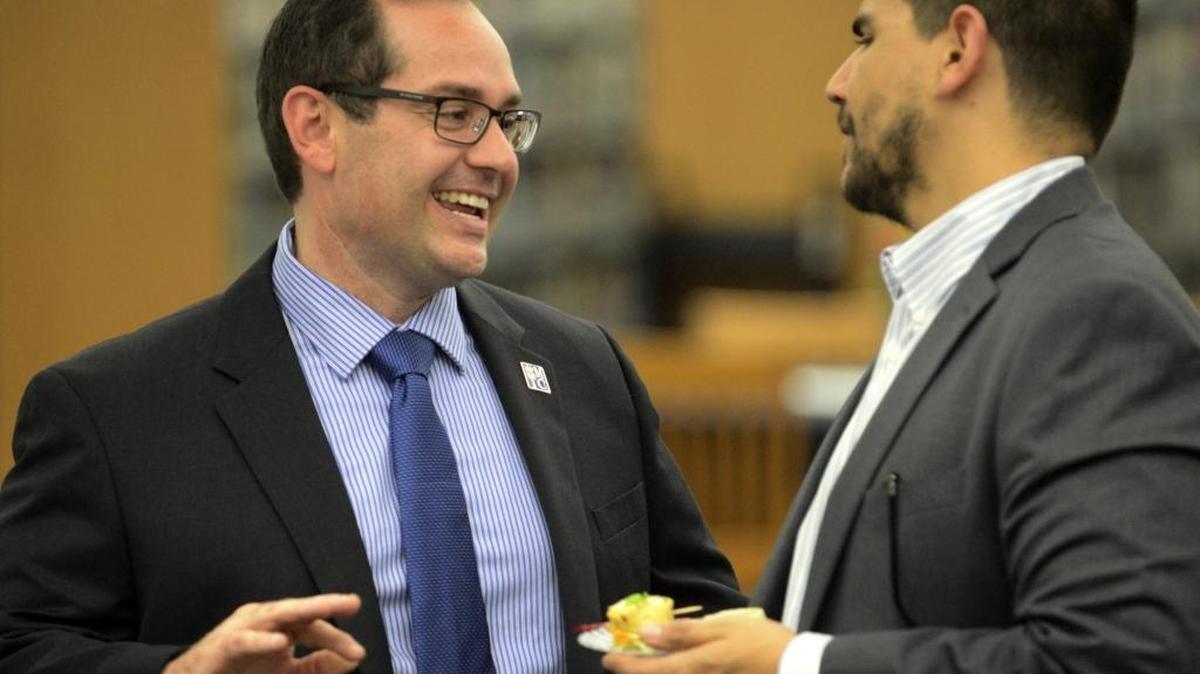Merced College President Chris Vitelli speak with a party-goer on Thursday, March 16, 2017 in the school’s library during a reception for him. He's been in the new job for more than two months.