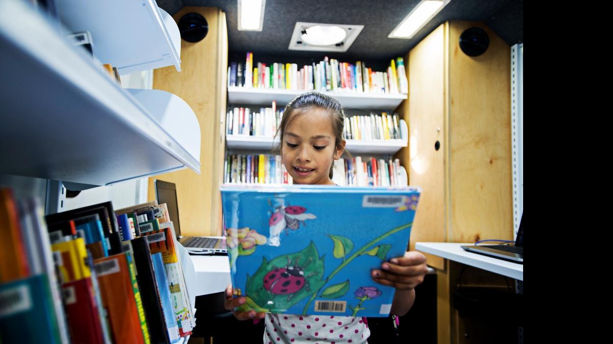
Arivel Cervantes, 8, of Merced picks up a book while browsing onboard the Merced County Library Bookmobile as it makes its first stop at Stephen Leonard Park in Merced in March.
