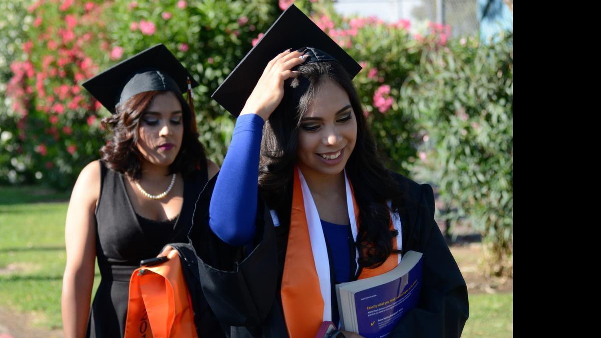 
Jessica Mena, 17, right, and Stephany Cruz head toward their graduation ceremony Thursday. The Merced High School graduates have big plans for their future. Mena plans to attend junior college before heading to the Fashion Institute of Design and Merchandising in Los Angeles. Cruz plans to study criminal justice and hopes to become a detective.
