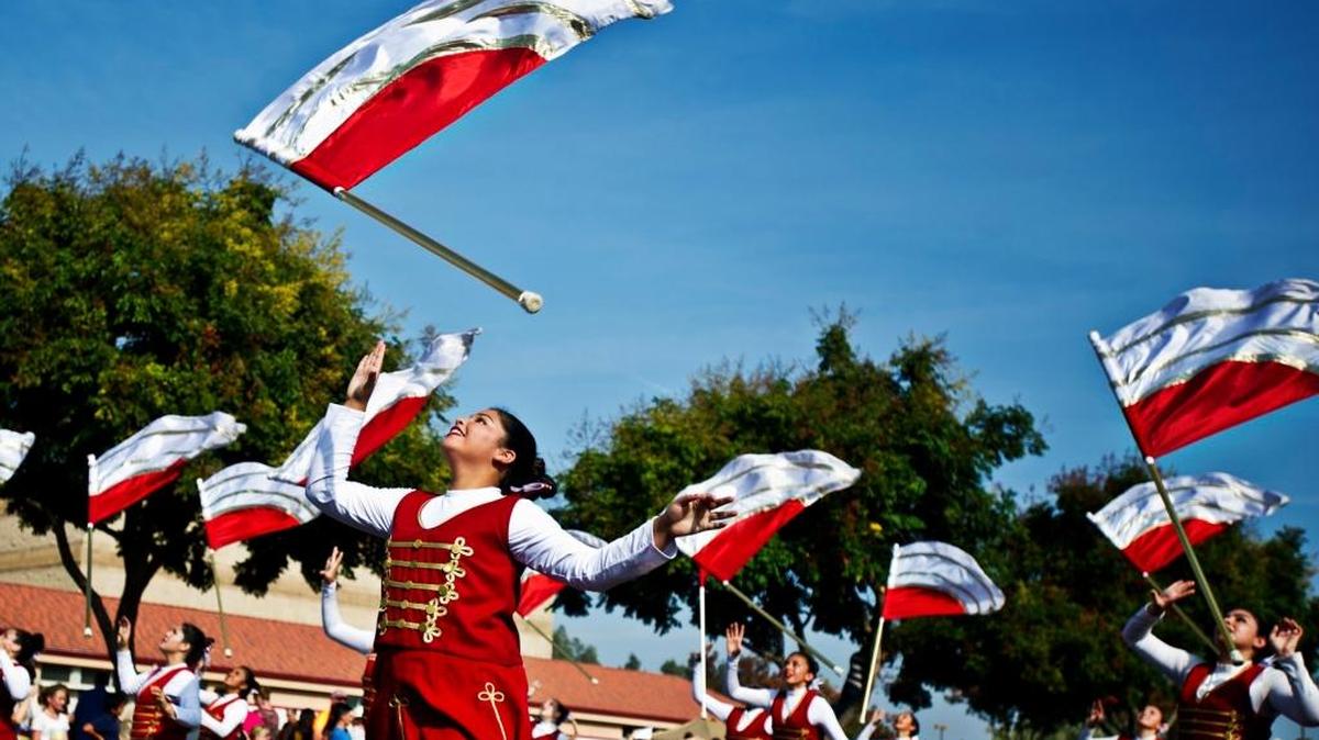 Members of the Golden Valley High School color guard toss flags into the air while performing with the marching band on East Childs Avenue during last year’s annual Central California Band Review at Golden Valley High School in Merced.