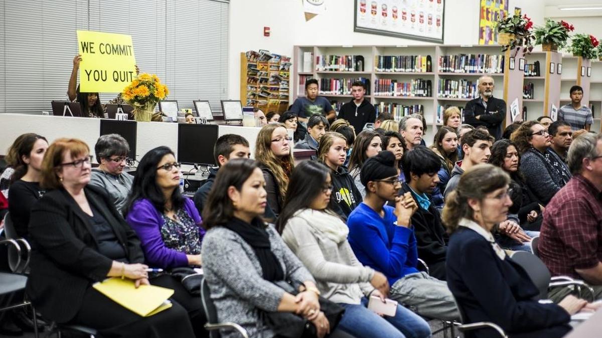 Buhach Colony High School freshman and International Baccalaureate student Inayat Hundal, left, holds a sign that reads “we commit you quit” during a Merced Union High School District board meeting at Buhach Colony High School in Atwater on Wednesday, Dec. 9, 2015. Parents and students expressed their disapproval of the district’s decision to end the International Baccalaureate program at Buhach Colony.