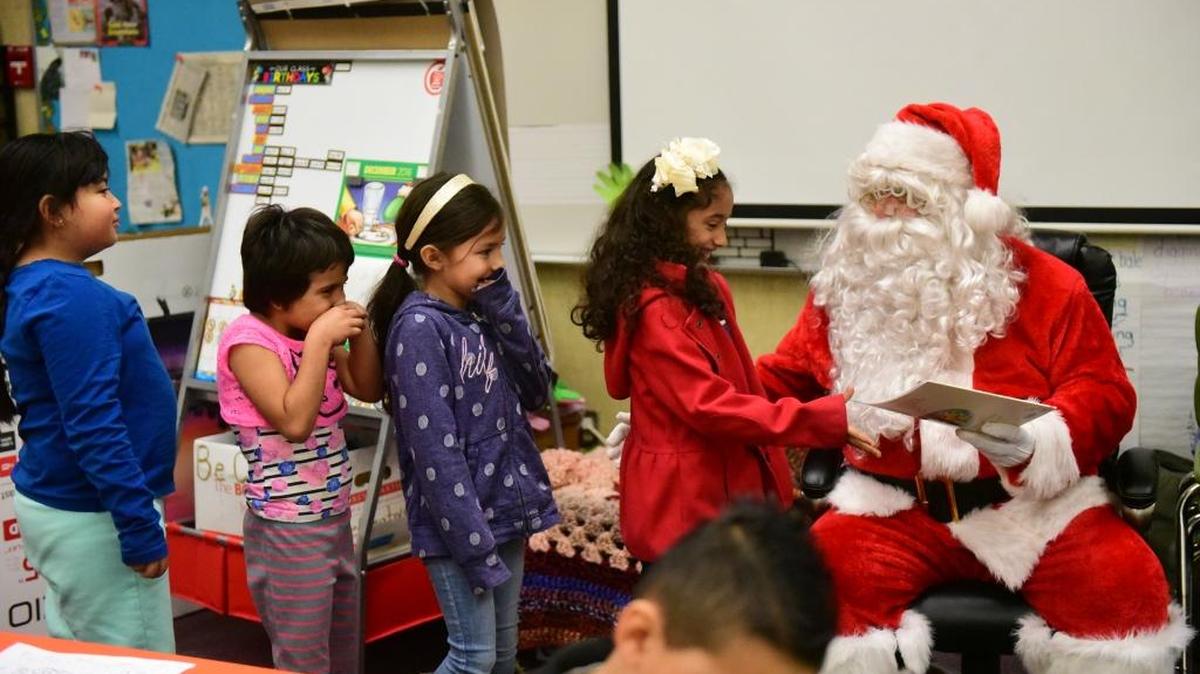 Four girls in Gale Boucher's first grade class at Cressey Elementary School on Dec. 15, 2016. They are waiting to receive books from Santa Claus donated by paid call firefighters from the Cressey Fire Department.