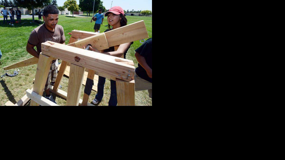 
Manuel Silva and Brenda Ceja, both 20, put together their trebuchet before launching a basketball dozens of meters through the air at Merced College last year. 
