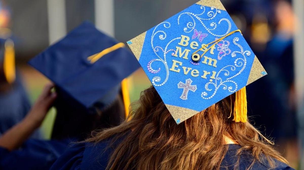 Cindy Roberts, 46, of Merced dons a mortarboard that her 10-year-old daughter, Trinity, help her decorate as she mingles with more than 1,000 graduates before they file into Merced College’s stadium for the 52nd commencement ceremony on May 22, 2015.