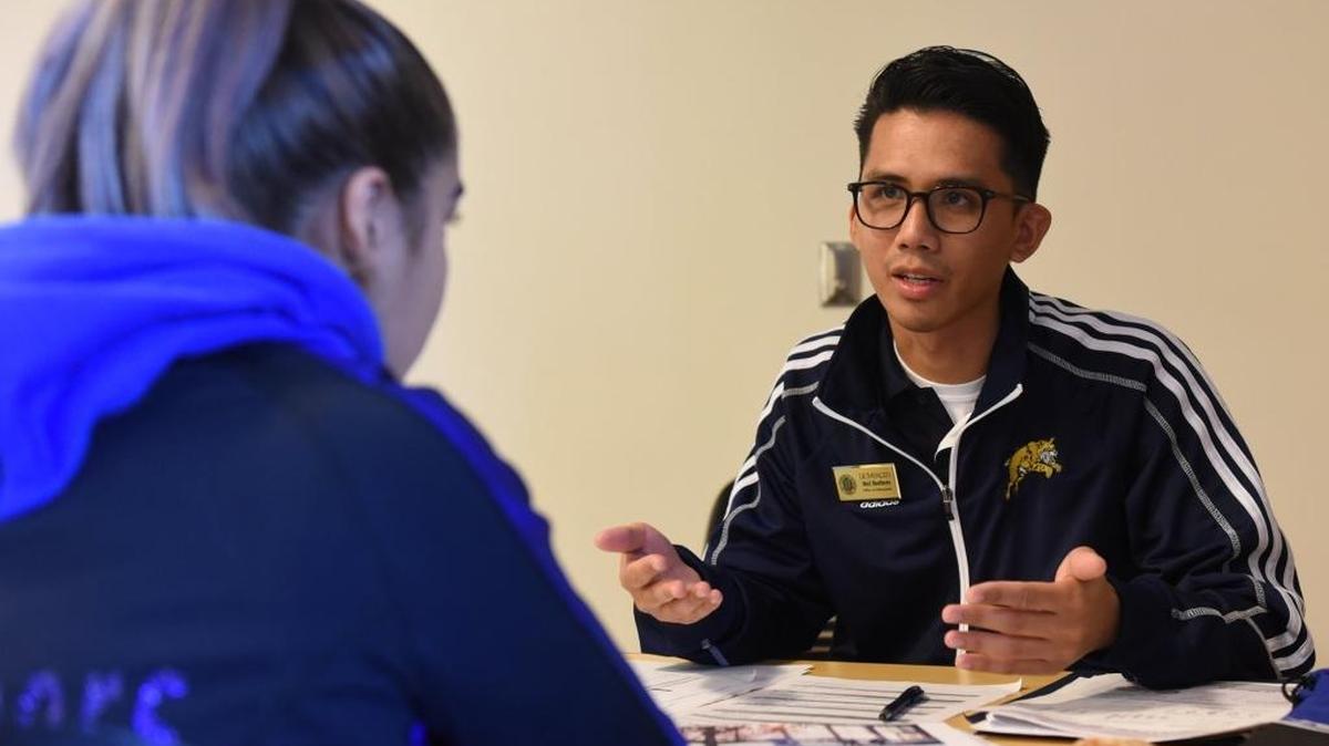Mel Barbers, an admissions evaluator, speaks with a Dinuba High School senior at UC Merced during an Achieve UC event Friday.
