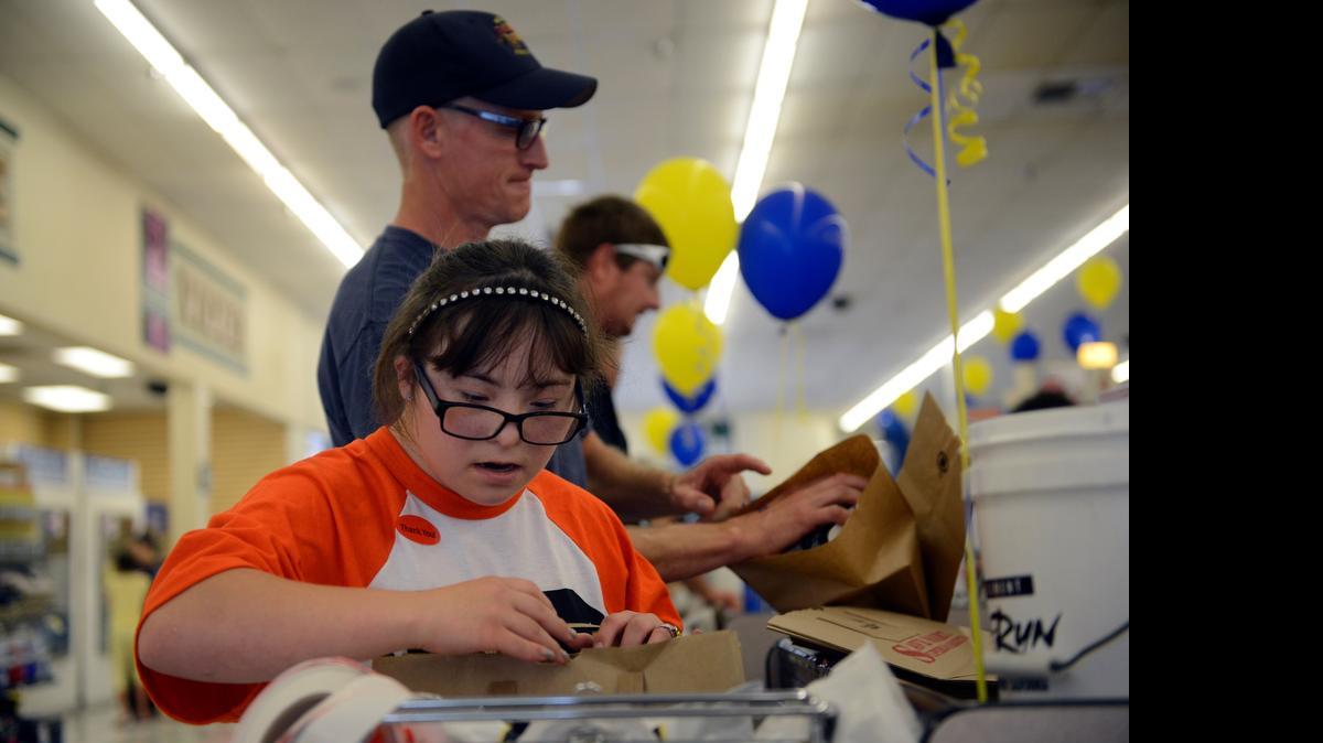 
Maggie Mayo, 18, who competes in basketball and track and field, bags groceries at Save Mart in Merced on Wednesday as part of the “Bagging for Bucks” fundraiser for the Special Olympics of Northern California. She was accompanied by employees of UC Merced’s Department of Public Safety. Shoppers dropped money into a bucket set out to benefit the annual athletic event.
