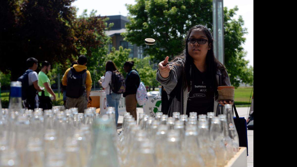 
Elizabeth Balbuena, 21, a senior who studies cognitive science, tosses a plastic ring toward recyclable bottles at UC Merced’s Earth Day event Thursday. The campus’s main walkway took on a carnival atmosphere for the day that promotes conservation.
