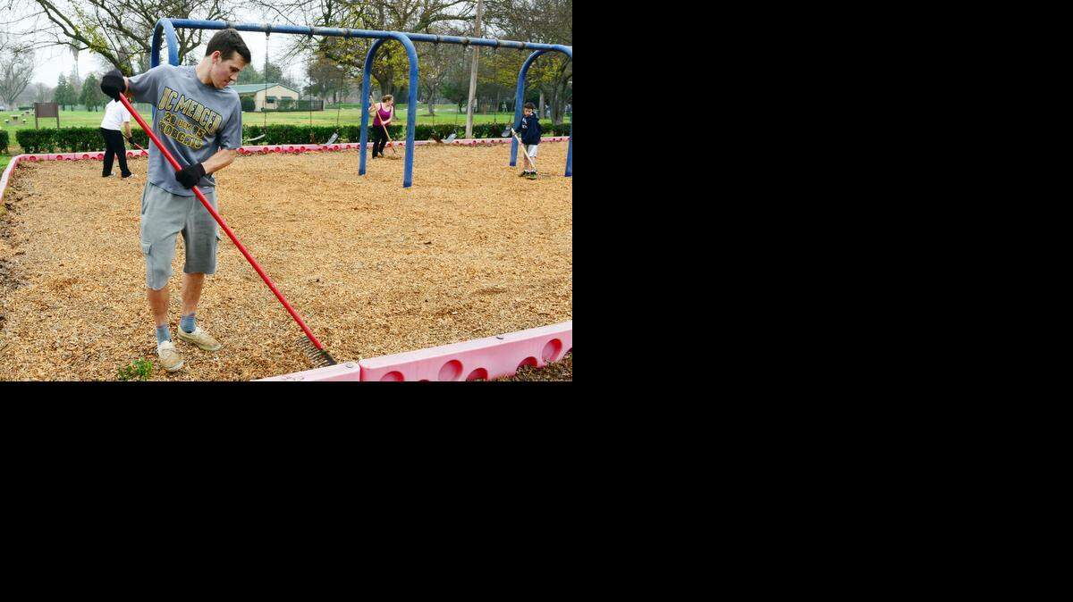 
Michael Pierick, 21, a UC Merced junior from San Diego, spreads bark on an Applegate Park playground on Monday, which was the Martin Luther King Jr. Day of Service. Scores of UC Merced students took part in projects around the park.
