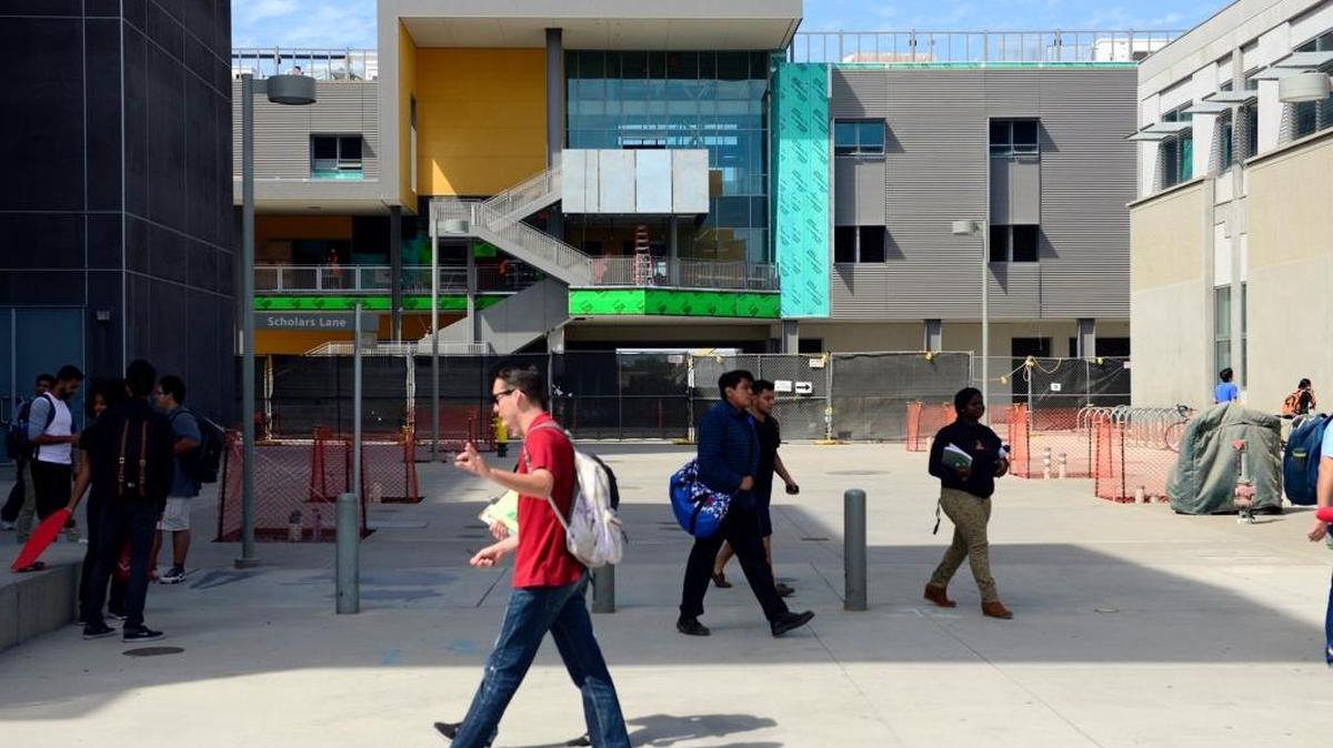 
Students travel to and from classes near Classroom and Office Building 2, the final structure under construction during the first phase of the school, at UC Merced in September. The school reported on Tuesday that it has invested nearly $170 million in the San Joaquin Valley economy in the past year.
