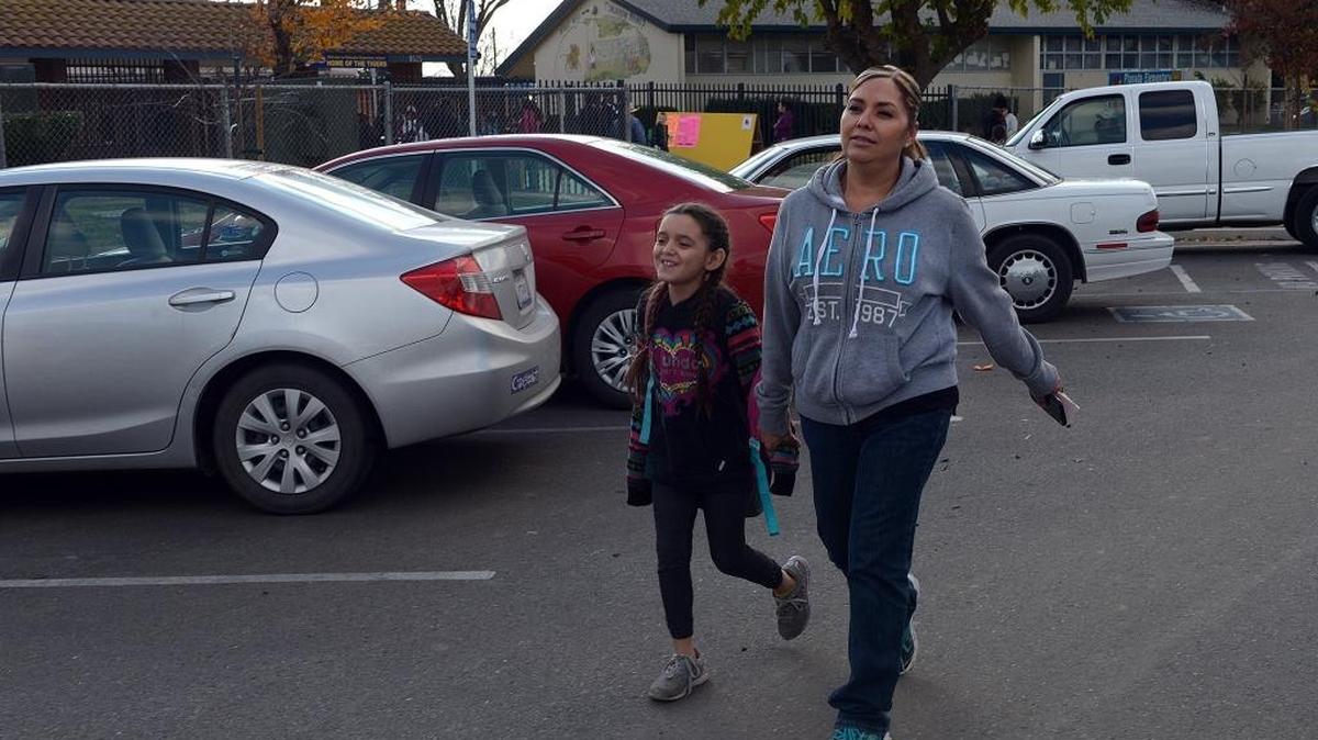 Martha Guzman picks up her daughter Harsha Lopez, 8, from Planada Elementary School on Tuesday, Dec. 15, 2015. The school district starts its winter break next week but Guzman will begin her children’s holiday a little early to travel to Mexico.