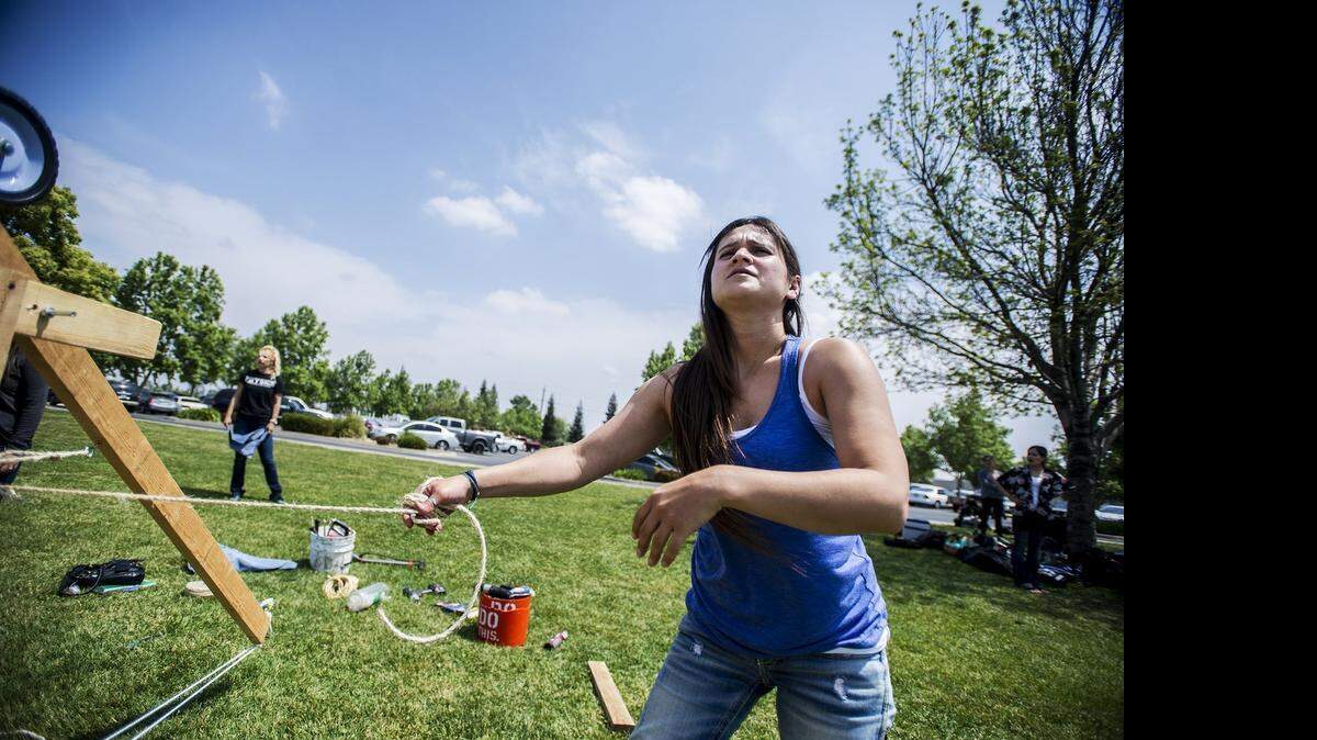 
Lythia Meza, 31, pulls on a rope to fire her team’s trebuchet Wednesday during the Siege Weapons Competition at the Merced College in Merced, Calif. 
