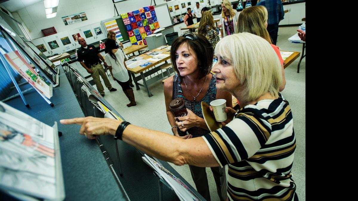 
Merced High School principal Amy Pellissier, left, and retired Merced High art teacher Sue Thompson look over student artwork during a show at Merced High School on April 29. The show featured work from five students who each produced 24 pieces of art over the school year.

