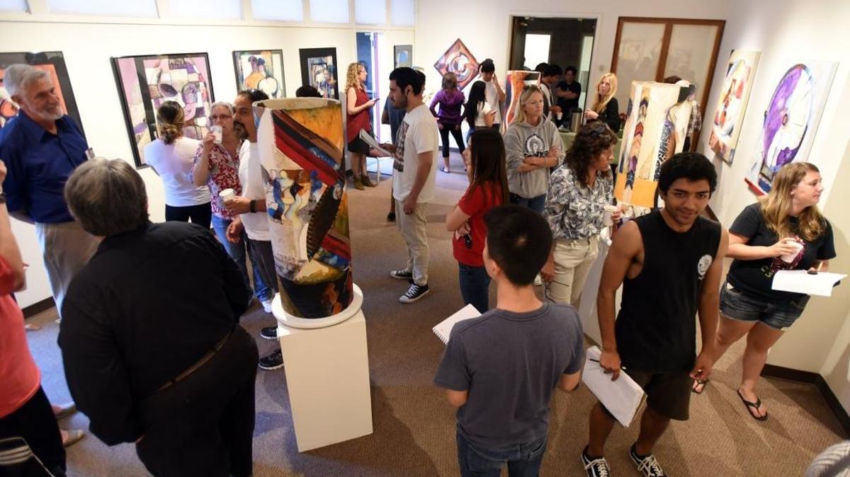 Museum-goers check out the “Rebirth of a People” exhibit on Wednesday during the opening reception. The mixed media work is featured through April 21.