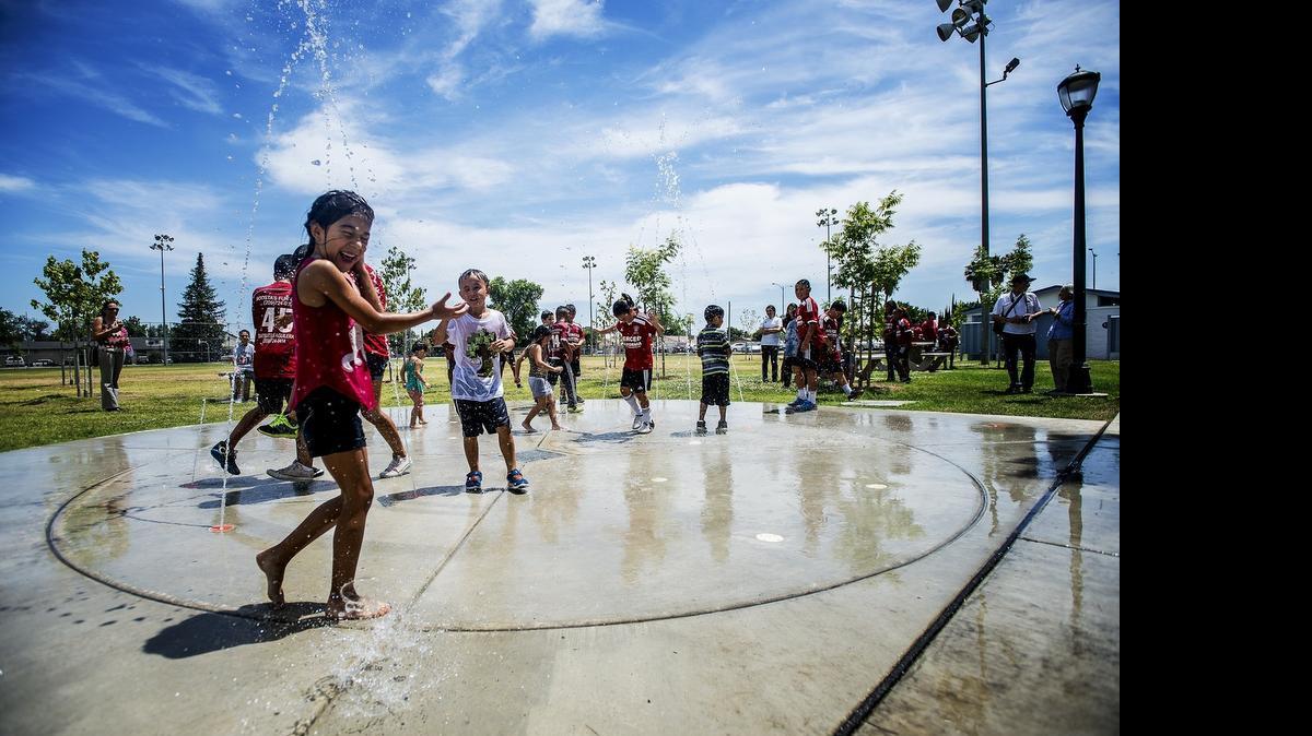 
Children run through the new Splash Pad following a dedication ceremony for the new artificial turf soccer pitches at McNamara Park in Merced on Tuesday. Parks and Recreation Department staff will develop a plan for the splash pad to keep from wasting water.
