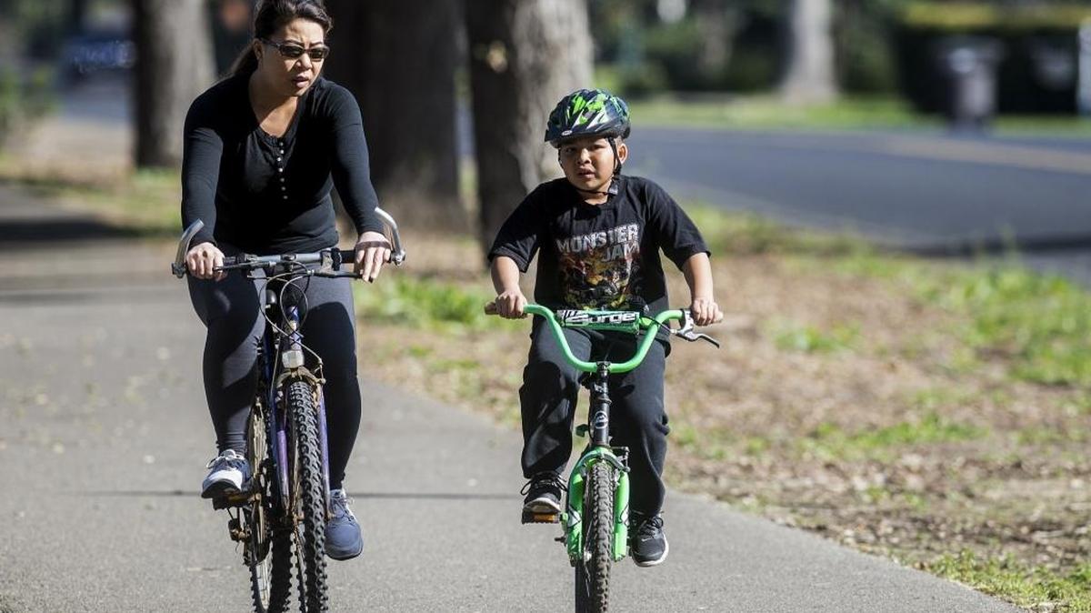 Sandy Syharath, left, and son Tristan, 7, ride along South Bear Creek Drive in Merced on Friday, Feb. 12, 2016. Merced has recorded zero rain for the month of February. According to the National Weather Service, warm weather is not unusual for an El Niño cycle and there may be more wet weather to come.