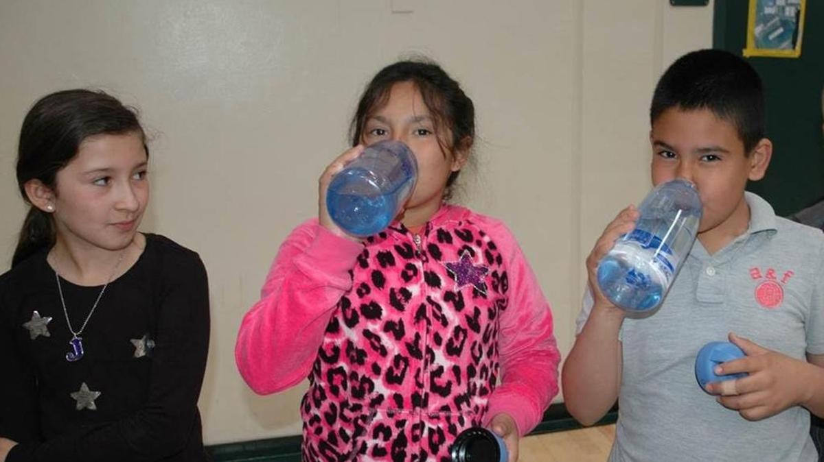 Le Grand students drink from their new water bottles on Thursday. Schools received new water filling stations this week.