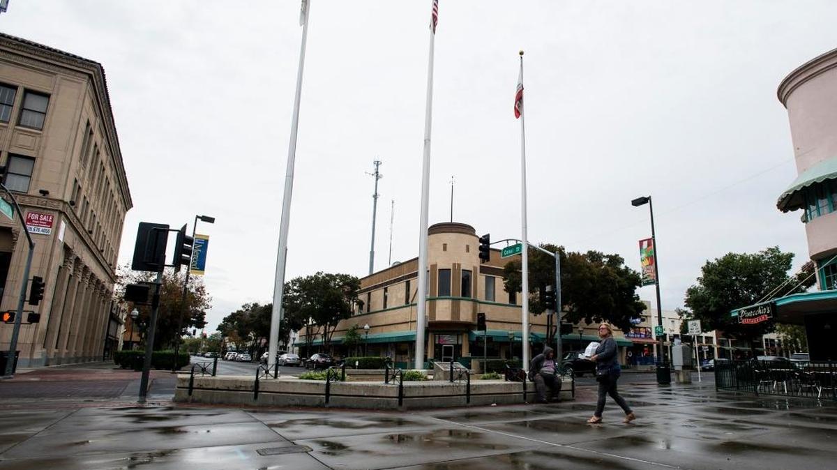 A pedestrian walks through a wet Bob Hart Square following a brief rain shower in Merced, Calif., Thursday, Oct. 27, 2016.