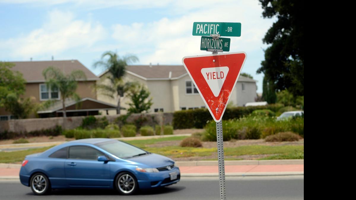 
A motorist passes through a roundabout at Horizons Avenue and Pacific Drive on Saturday near the site of a planned apartment complex in Merced that would have more than 100 units. The Merced City Council on Monday approved a zone change that will allow the developer to build the complex. 
