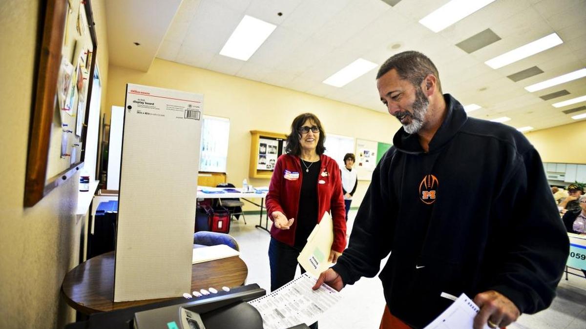 Kurt Smoot, 47, of Merced casts his ballot with the assistance of volunteer Dianne Correia, 64, at the Shepherd of the Valley Lutheran Church in Merced, Calif., in November 2014.