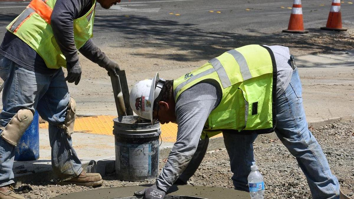 
Cement masons Richard Jimenez and Celedonio Jimenez, left, work in the heat of the day to construct manholes in the parking lot of the Merced County Administration Building on Monday afternoon on 23rd and M streets in Merced.
