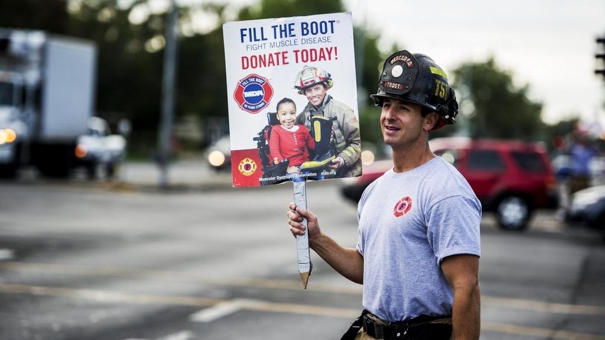 Merced Fire Department engineer Jeff Trost stands near the intersection of G Street and Olive Avenue during the Fill the Boot fundraiser benefiting the Central California chapter of the Muscular Dystrophy Association in Merced, Calif., Wednesday, Oct. 28, 2015.