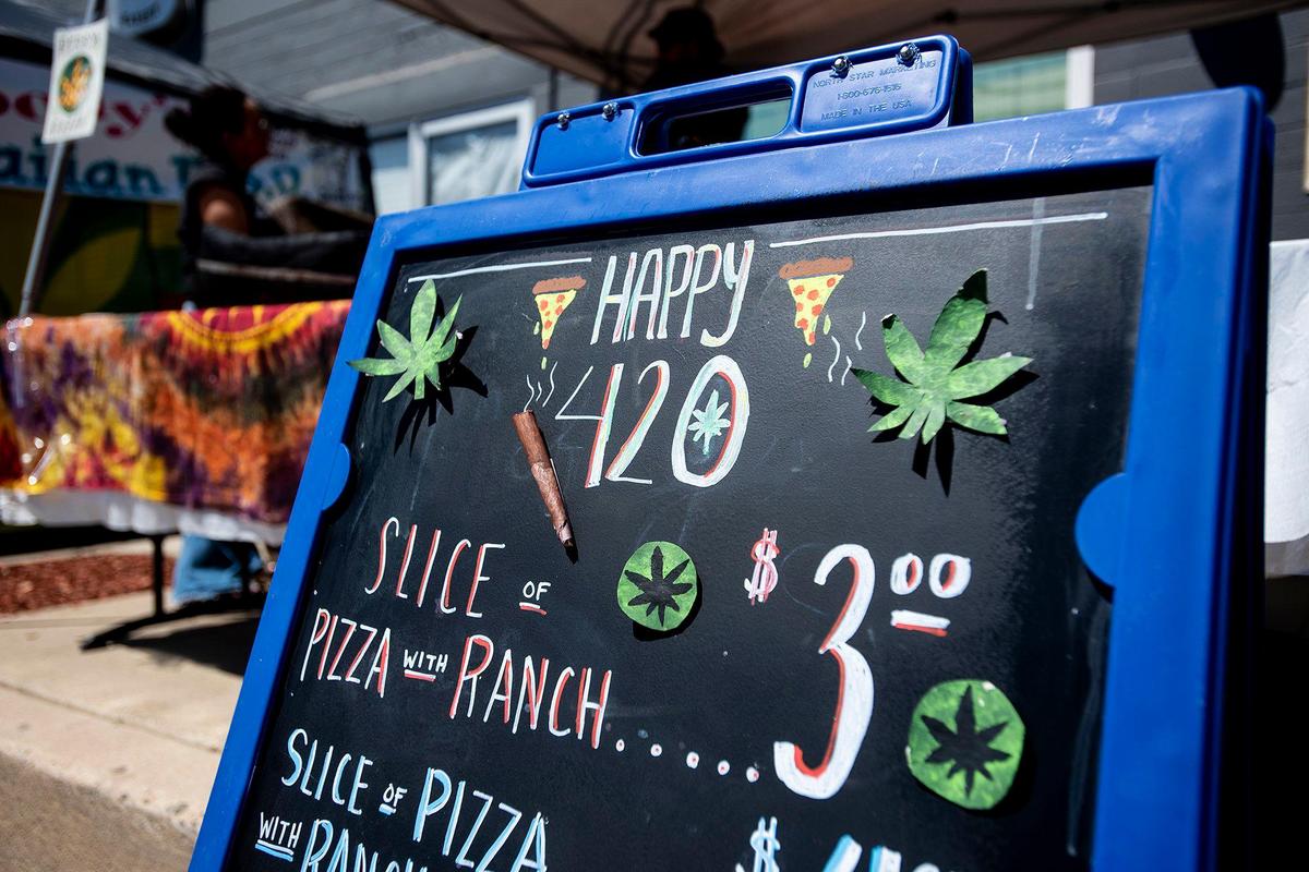 A sandwich board decorated to celebrate 420 on Third Avenue in Gustine, Calif., on Wednesday, April 20, 2022. The event included smoke shop items for sale, food vendors and live music.