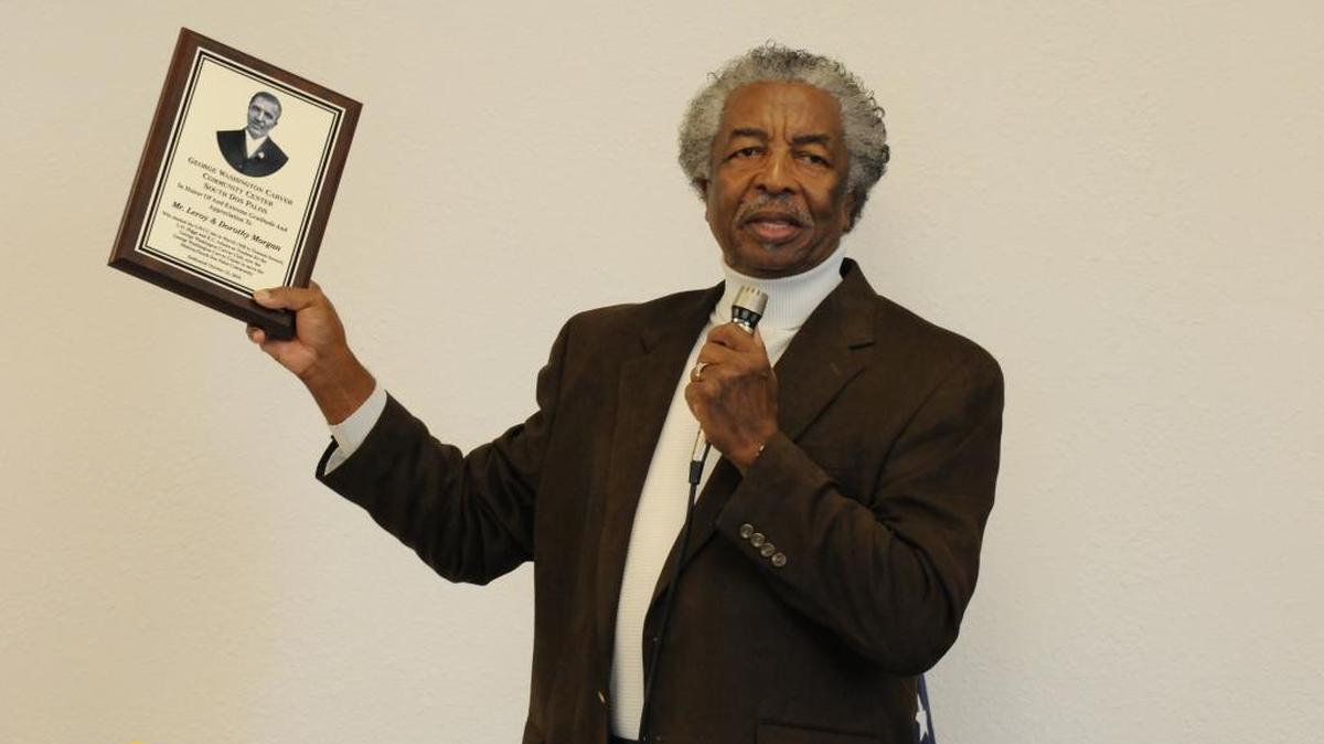 
Denard Davis holds up one of dozens of award plaques featuring the likeness of George Washington Carver as he makes a speech during the grand opening of the newly revamped George Washington Carver Community Center in South Dos Palos in 2010.
