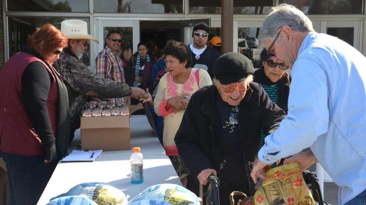 Volunteers help give out free turkeys and packages of almonds during local farmer and developer Greg Hostetler’s annual turkey giveaway event Tuesday, Nov. 22, 2016, at the Los Banos Fairgrounds.