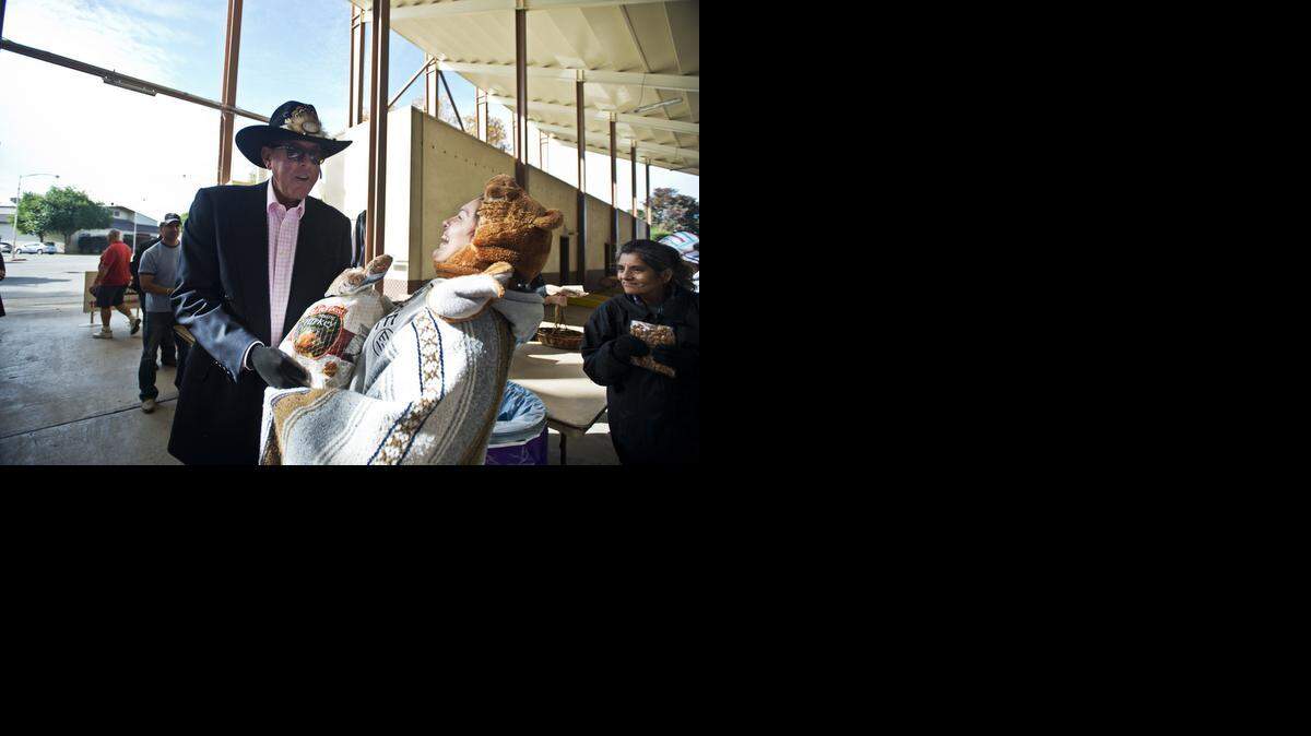 
Greg Hostetler, owner of Hostetler Ranches, laughs with Maria Torres Cardenas, 36, of Merced during a free turkey giveaway at the Merced County Fairgrounds on Sunday. Cardenas, who arrived at 5:30 a.m., was the first person in line to receive one of 500 turkeys and 500 bags of almonds during the giveaway. Hostetler has been organizing the event for over 30 years.
