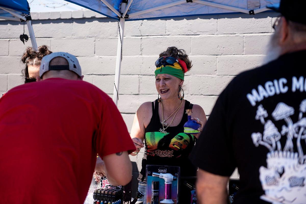 Karie Kuehl of Fresno, center, helps a customer during a 420 celebration on Third Avenue in Gustine, Calif., on Wednesday, April 20, 2022. The event included smoke shop items for sale, food vendors and live music.