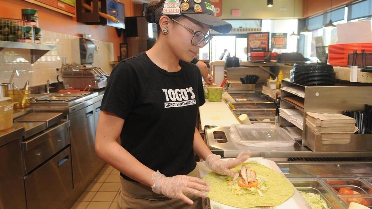 Jacinda Hernandez prepares a chicken bacon spinach wrap Wednesday afternoon at Togo’s in Los Banos.