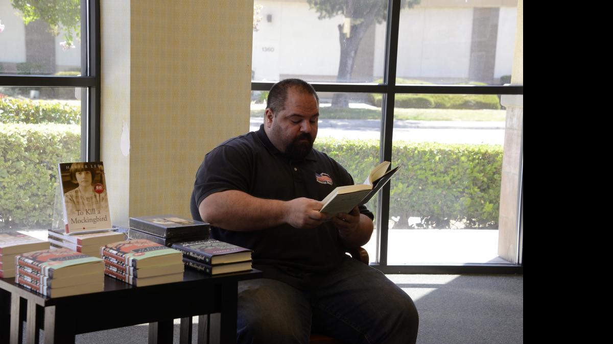 
Atwater City Councilman  Brian Raymond reads Harper Lee’s first novel, “To Kill a Mockingbird,” on Monday at the Barnes & Noble in Merced ahead of the release of Lee’s second novel, “Go Set a Watchman.”
