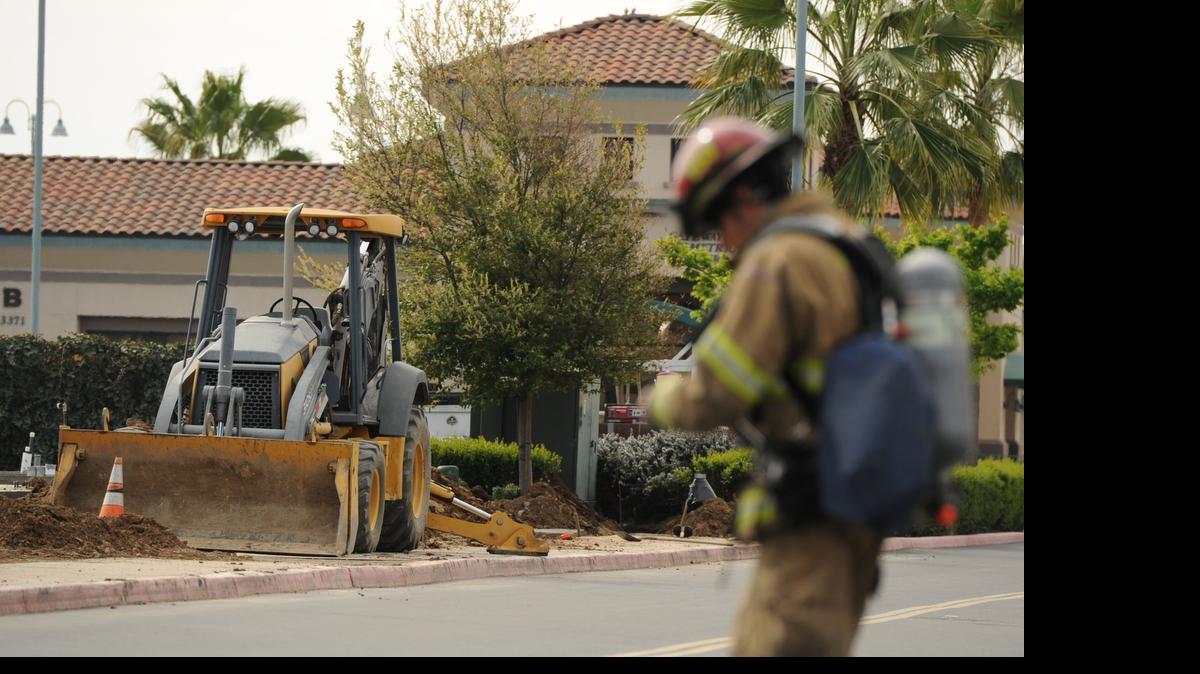 
A Merced firefighter walks past the site where a construction backhoe struck a low-pressure gas line at the El Portal medical plaza in Merced in March 2013. Pacific, Gas and Electric Co. is working on a plan in Merced to move dozens of trees and other obstructions that would slow down the work of first responders. 
