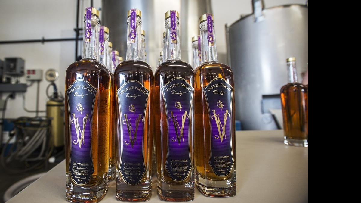 
Bottles line up on a table as the first labels are applied to Velvet Night Brandy in Atwater on Friday. Velvet Night is a small-batch brandy distilled and sold by In Distill of the Night Spirits, owned by Ken Andrus, 67, of Fresno. Andrus, a former pharmacist, has been making brandy for the past five years.
