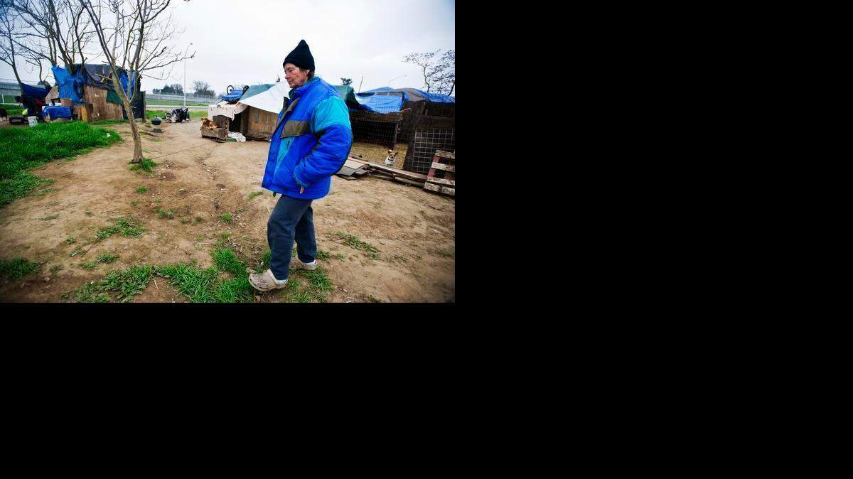 
Gail Henslee, 60, walks through the homeless camp near Highway 140 and Kelly Avenue in Merced on Thursday.  Camp residents were notified Thursday morning that they have until 8 a.m. Monday to vacate the property, which is owned by the California Department of Transportation.
