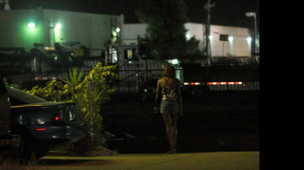 
A woman walks the motels along 16th Street in September 2013.
