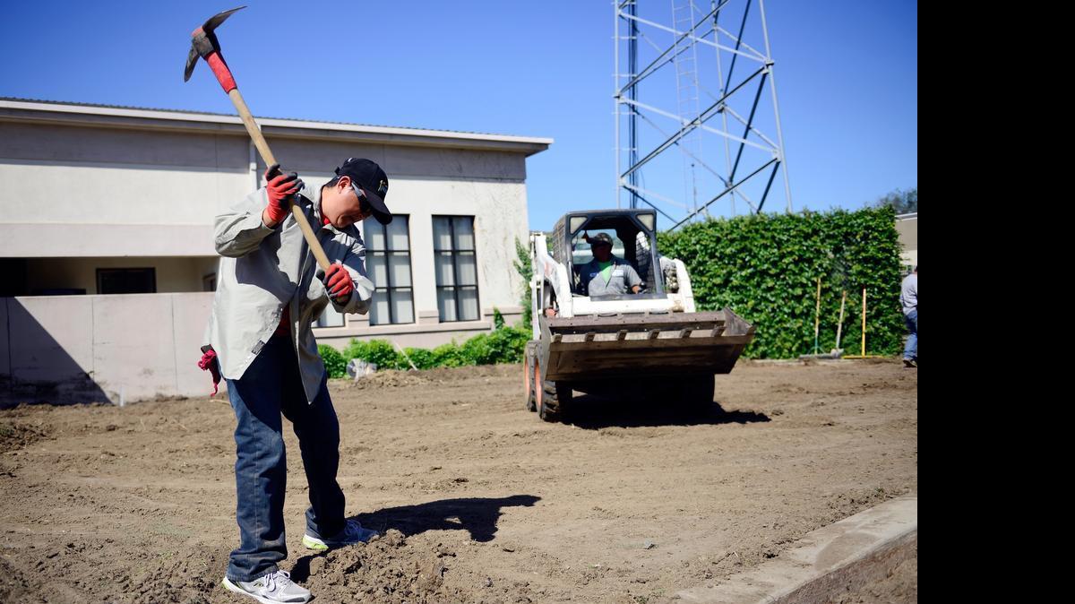 
Yard Masters employee Gerardo Diaz works on removing a sprinkler at Merced Fire Department’s Station 51 on Monday A crew will remove about 2,000 square feet of grass this week and replace it with a drought-tolerant landscape.
