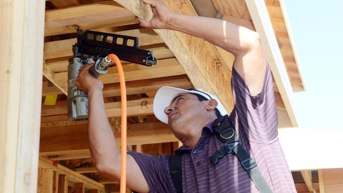 Francisco Castro, 39, of Livingston uses a nail gun on a home in Merced in 2014. The number of permits for new homes has increased for many area cities.