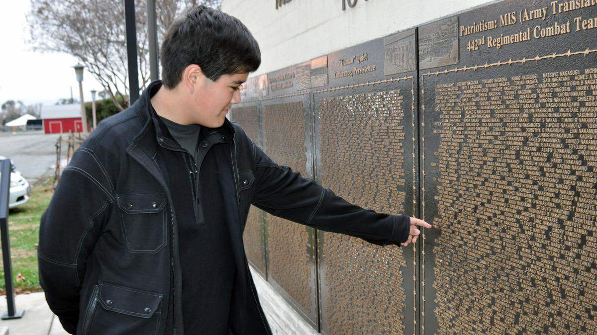 Grant Dunford, 14, points to his grandfather’s name, Harry J. Nishihara, on the plaques at the Merced County Fairgrounds honoring the more than 4,600 Japanese-American citizens who were interned on those grounds during World War II. A lawmaker is putting forth a resolution for the Legislature to apologize for the role in the internment.