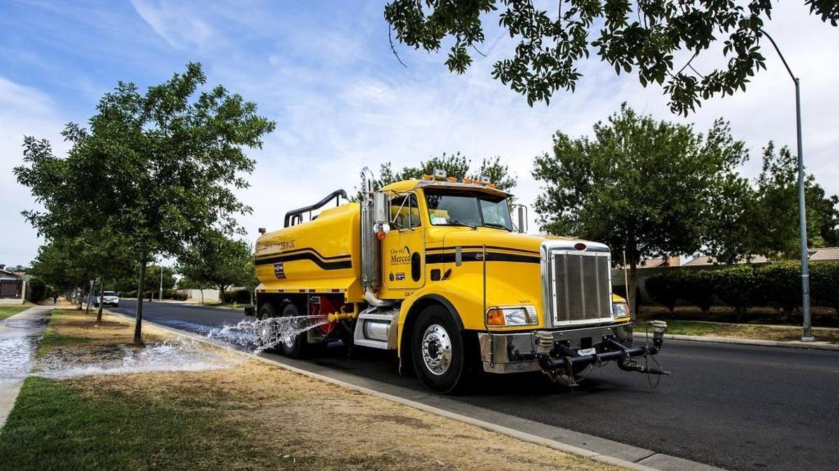 
A city truck uses recycled, nonpotable water Tuesday on trees along South G Street at Brooks Park in Merced.
