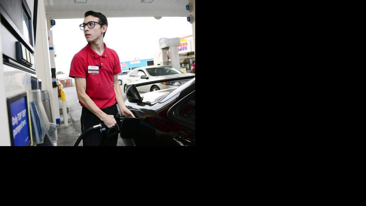 
Andrew Amavizca, 20, of Merced fills up his car’s tank with gas that costs $2.99 per gallon on Thursday in Merced. Prices around the Valley are coming down, according to experts.
