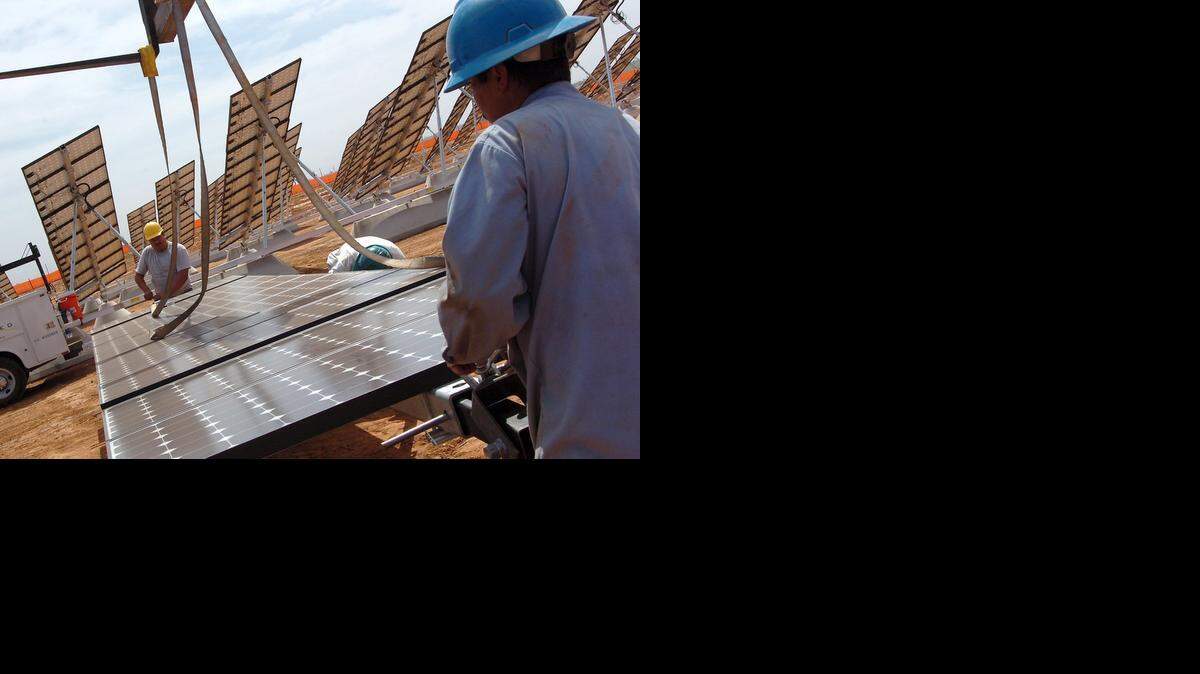 
Installers Julio Rodriguez, left and Joaquin Ortiz prepare another solar panel to be put into place on the UC Merced Solar Field in 2009. The campus plans to expand its solar farm and install panels on rooftops, which could help the campus get 100 percent of its energy from renewable resources by 2016.
