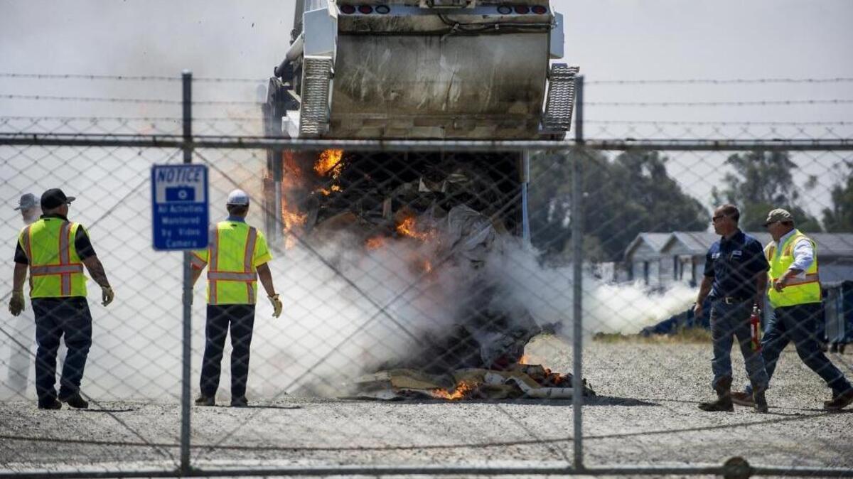 Merced city workers attempt to extinguish a fire after debris caught fire in a city garbage truck at a lot near the Merced County Publics Works Center at the intersection of Wardrobe Avenue and Thornton Road in Merced, Calif., on Thursday, April 27, 2017. According to Mike Schlessinger, lead refuse equipment operator, the contents of the truck appeared to catch fire while driving after city workers removed items from two homeless camps. One of the camps was located near D Street and 15th Street with the other located near 15th Street and Canal Street. Merced City Fire responded to the call.