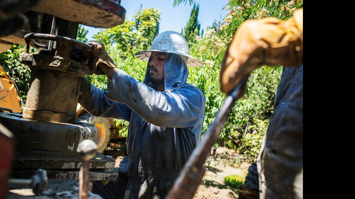 
Calwater Drilling Co. employee Albert Munoz, 21, of Turlock, drills a new residential well at a home on Belmira Road in Atwater in June. A Visalia nonprofit, Self-Help Enterprises, has received approval to install and maintain emergency water distribution systems for Merced County residents whose wells have dried up.



