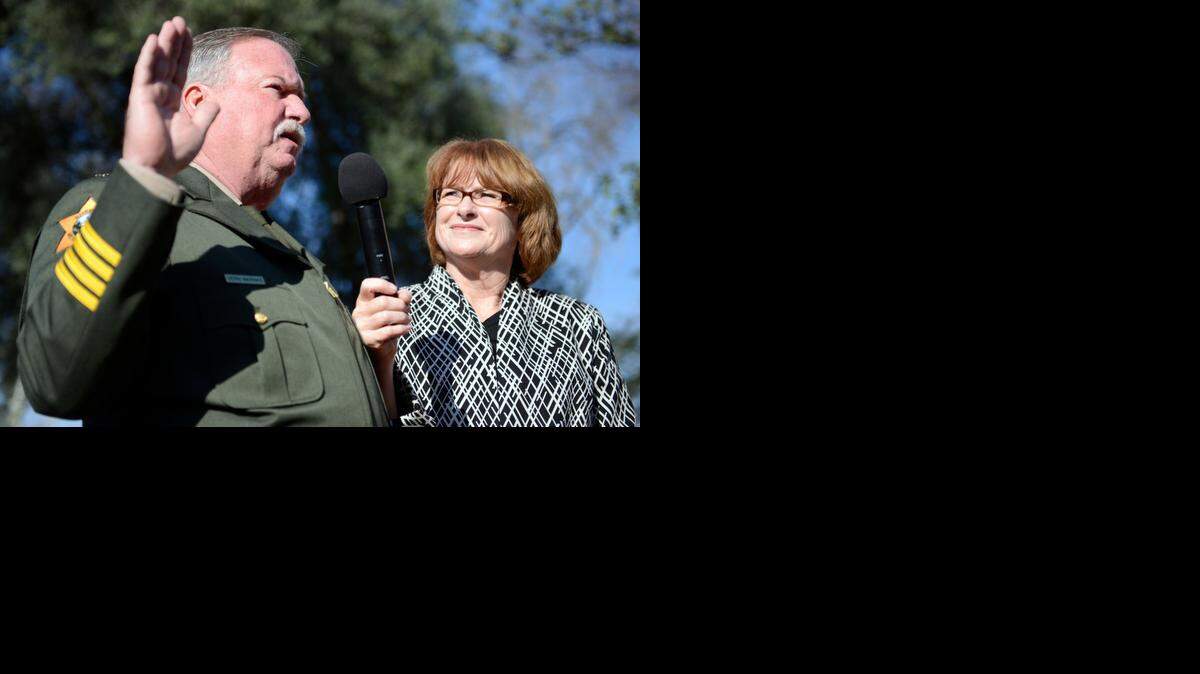 
Merced County Sheriff Vern Warnke is sworn in while standing next to his wife, Kathy, in front of the Merced County Courthouse Museum on Monday.  A deputy sheriff and five cadets were sworn in as well.
