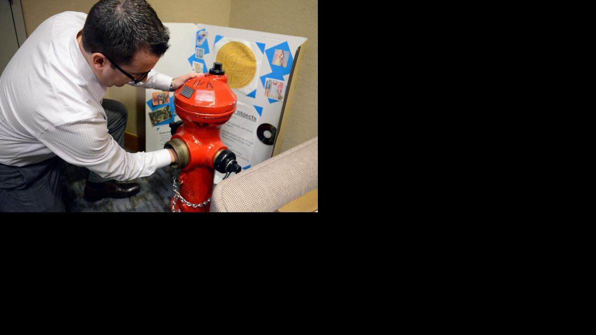 
Councilman Mike Murphy reaches inside the Merced time capsule, which was once a city fire hydrant, in the mayor’s office at City Hall on Tuesday. The final day to submit an item for the capsule is Jan. 15. 
