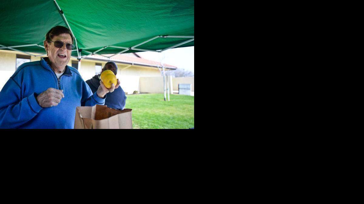 
Don Bergman, president of the nonprofit Make Someone Happy food truck, bags produce for a county employee at the Merced County’s Human Services Agency building in Merced last month. 
