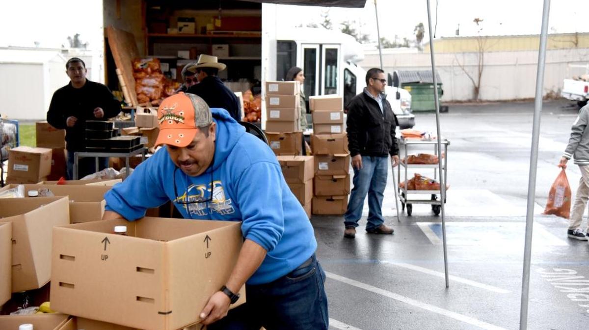 Jose Gutierrez, 51, of Atwater picks up a box with food while working at the Central Valley Opportunity Center’s annual Christmas food basket giveaway on Tuesday, Dec. 22, 2015, in Winton.