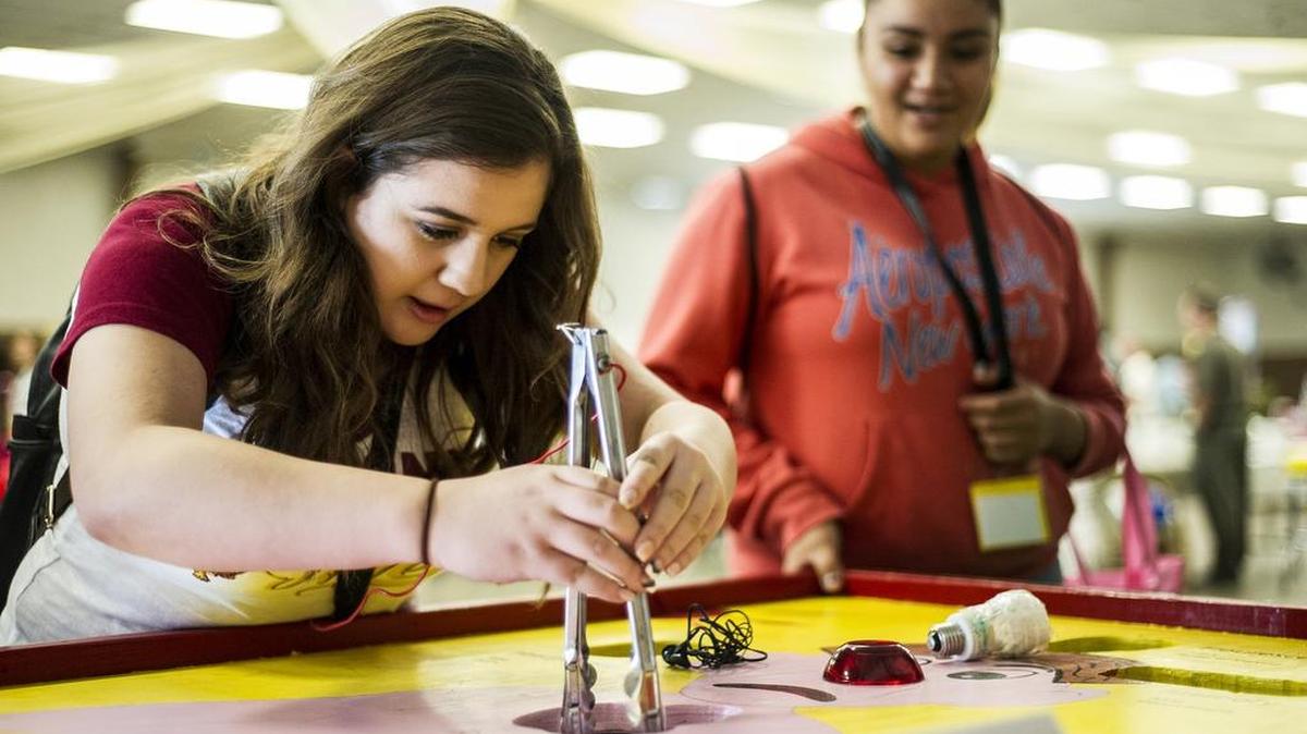Los Banos High School sophomore Susannah Gomez attempts Thursday to pull an object out during a game of Operation at the Merced County Office of Education's annual Career Industry Day at the Merced County Fairgrounds.
